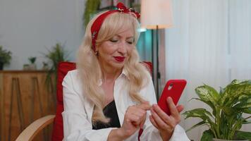 mayor abuela a hogar silla utilizar teléfono inteligente celebrar genial grande lotería ganar bote, bueno Noticias video