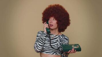 bonito mujer con marrón lozano peluca hablando en cableado Clásico teléfono de Años 80 dice Oye usted llamada yo espalda video