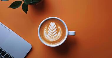 Cup of Coffee on Table Next to Laptop photo