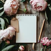 Notepad, Pencil, and Flowers on Wooden Table photo