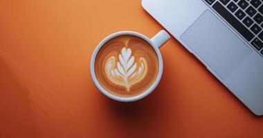 Cup of Coffee on Table Next to Laptop photo