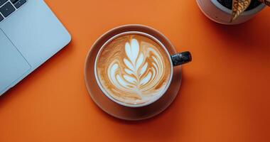 Cup of Coffee on Table Next to Laptop photo