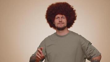 Bearded optimistic young man showing victory sign, hoping for success and win, doing peace gesture video