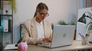 Businesswoman working on laptop at office wearing earphones listening favorite energetic disco music video
