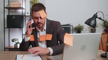 Tired sad exhausted businessman working on laptop at office with many sticker tasks, panic attack video