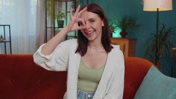 Happy cheerful young woman looking approvingly at camera showing ok gesture, positive like sign video