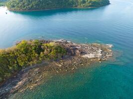 Aerial drone view of beautiful rocky with turquoise sea water and trees of Gulf of Thailand. Kood island, Thailand photo