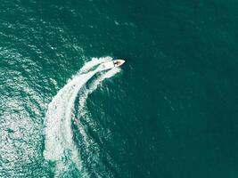 Aerial view of Speed boat at high speed in the aqua sea, Drone view photo