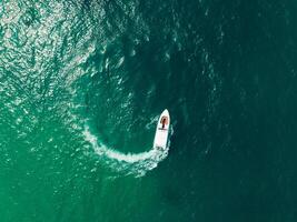 Aerial view of Speed boat in the aqua sea making a circle, Drone view photo