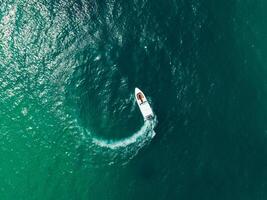 aéreo ver de velocidad barco en el agua mar haciendo un círculo, zumbido ver foto