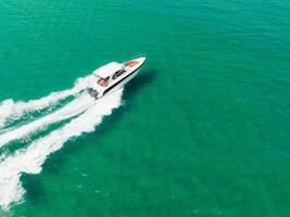Aerial view of Speed boat at high speed in the aqua sea, Drone view photo