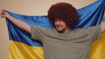hombre sostener Ucrania nacional bandera esperando para éxito, independencia, libertad, victoria en guerra, fiesta video