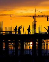 Construction workers at sunset photo