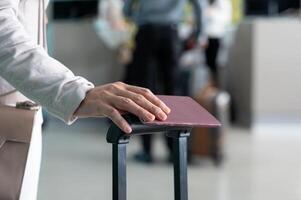 Business woman holding passport with luggage at airport terminal photo