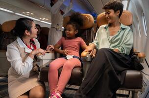 Airplane flight attendant providing service to kid and mother passengers on board. photo