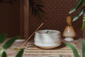 Japanese tea ceremony with a matcha. Tyawan, tyasaku, tyasen on a stone table top among bamboo leaves photo