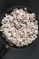 Sliced mushrooms in a frying pan are ready for frying photo