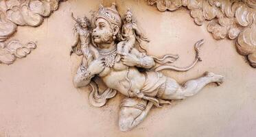 carving of lord hanuman flying in the sky photo