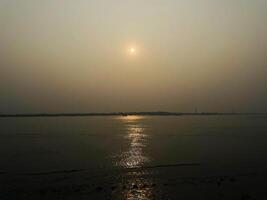 sunset view of ocean at the edge of beach photo