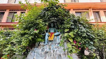 hindu god mahadev statue sitting in cave with trishul photo