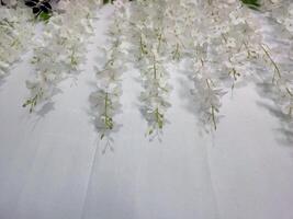 Photo of white spread flower decoration complete with green leaves on a white background