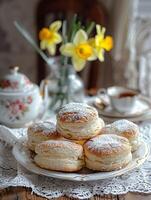 Welsh cream cakes with tea on a vintage lace tablecloth. photo