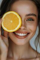 retrato de un joven mujer con brillante piel, participación un rebanada de limón cerca a su rostro. foto