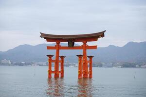 Miyajima Island, Japan - December 5, 2023 - Red Giant Grand Otorii Gate at high tide during winter Hiroshima City Hiroshima Prefecture Japan photo