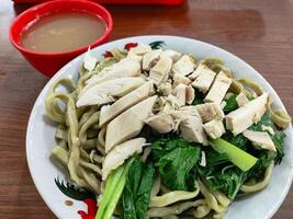 Delicious Asian Noodles with Chicken and Vegetables and Broth, Bakmi Karet photo