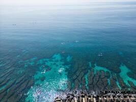 Aerial Tranquility, Swimmers Enjoying Crystal Waters by the Seashore in Taiwan photo