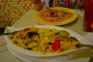 A plate of seafood noodles and a bowl of spaghetti are served on the table photo