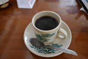 A cup of black coffee is served on the table photo