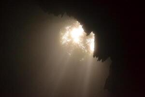 The ray of light in vertical grubug cave photo