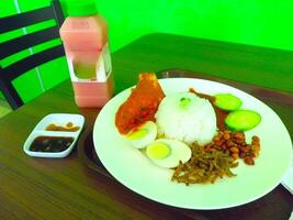 un plato de nasi lemak y instante jugo en el mesa foto