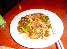 un plato de frito fideos en el mesa foto