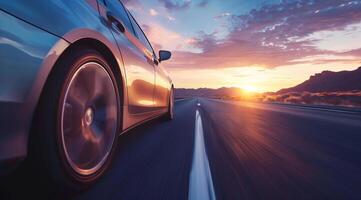 Low angle view of a modern luxury car on a road trip with a sunset in the background photo