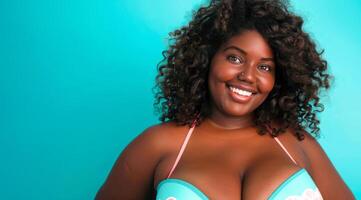 A plus size black afro-american bikini model with curly hair is smiling and wearing a bikini top photo