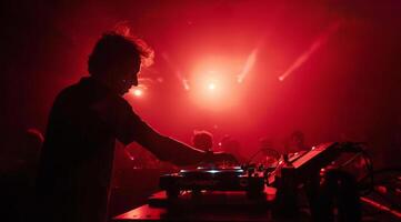 DJ es jugando moderno electrónico música a un popular Club nocturno foto