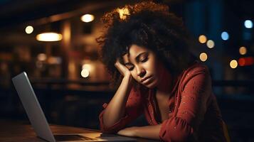 Professional burnout syndrome. Tired black skin female manager in office sitting at the laptop. Deadline, stress, depression at work photo