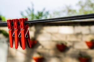 Three Red Clothespins on a Clothesline photo