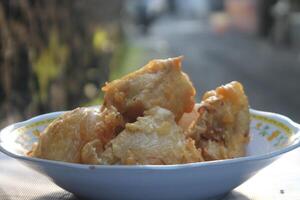 Close-up photo of Gorengan Tahu susur on white plate. Concept for junk food, unhealthy, diet, calories, bad fat, carbohydrate, snacks, cafe, fast food.