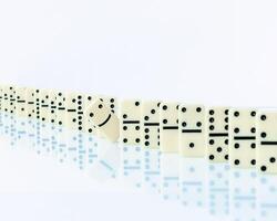 Domino piece stopping domino effect on white background. photo