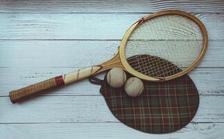 A vintage tennis racket with balls on wood background. photo