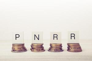 Stacks of coins with PNRR letters. UE economy concept. photo