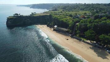 Drönare se av sandig strand med naturskön sten och blå hav i bali. balangan strand video