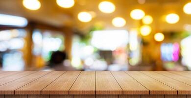 Empty wooden table top with lights bokeh on blur restaurant background. photo