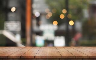 Empty wooden table top with lights bokeh on blur restaurant background. photo