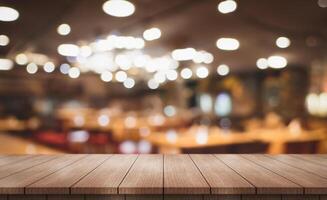 Empty wooden table top with lights bokeh on blur restaurant background photo