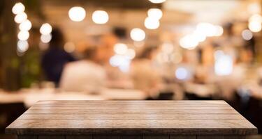 Empty wooden table top with lights bokeh on blur restaurant background photo