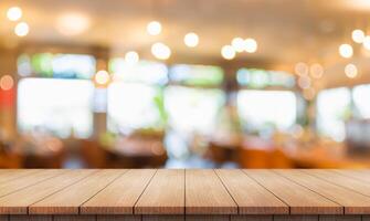 Empty wooden table top with lights bokeh on blur restaurant background. photo